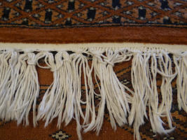 Before repair at the fringes on an oriental carpet