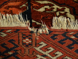 Before restoration of the fringes of a Turkoman carpet